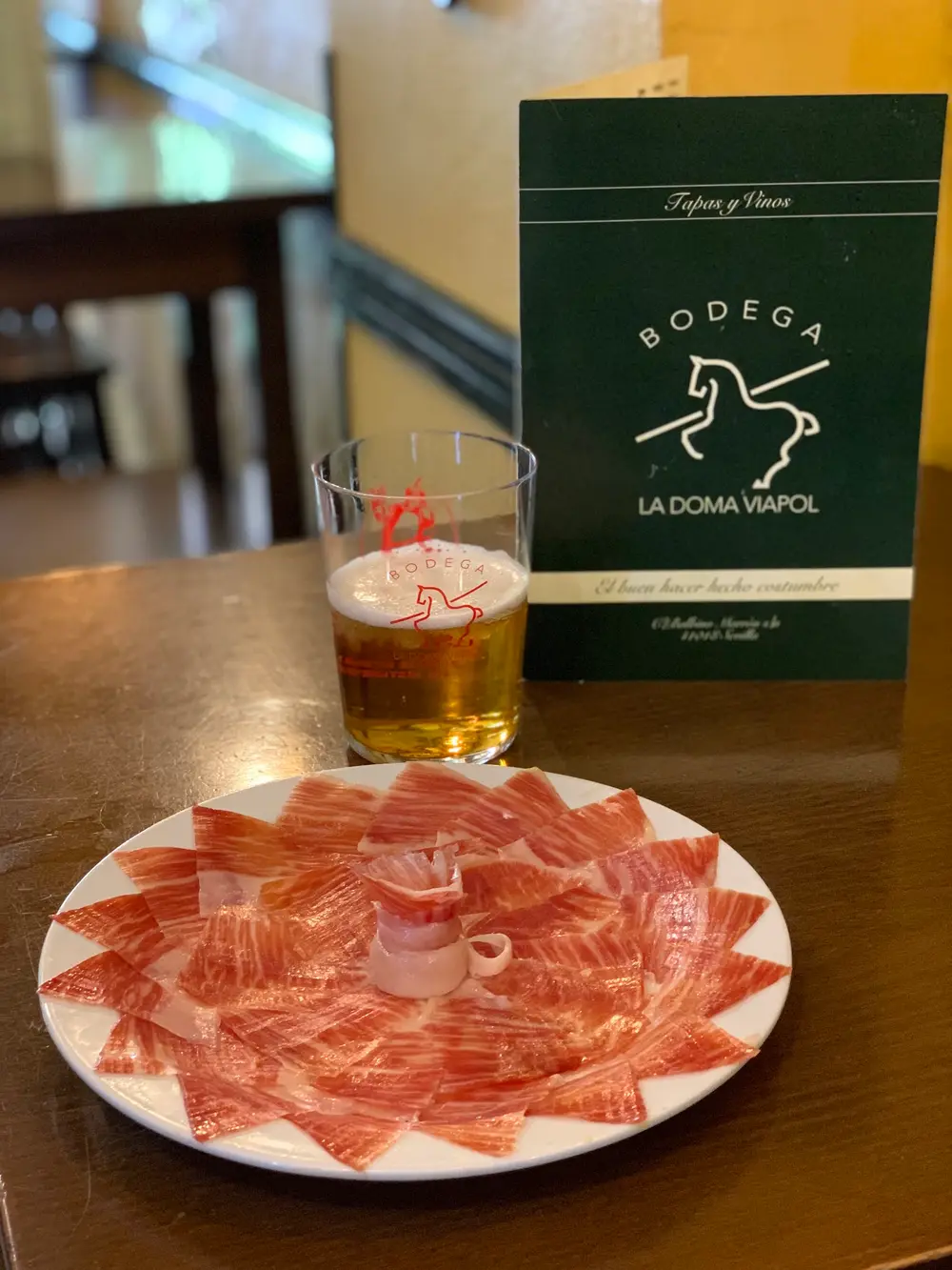 Un plato de jamón ibérico y una caña en la barra de La Doma
